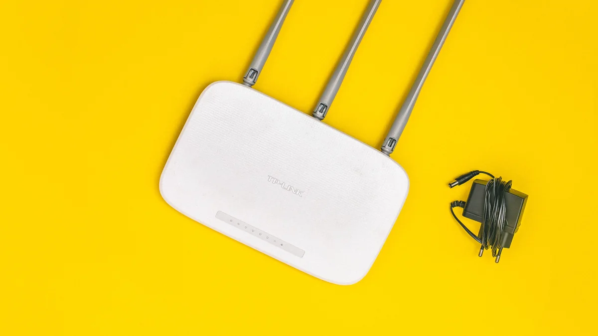Roteador doméstico com antenas e cabos em destaque.