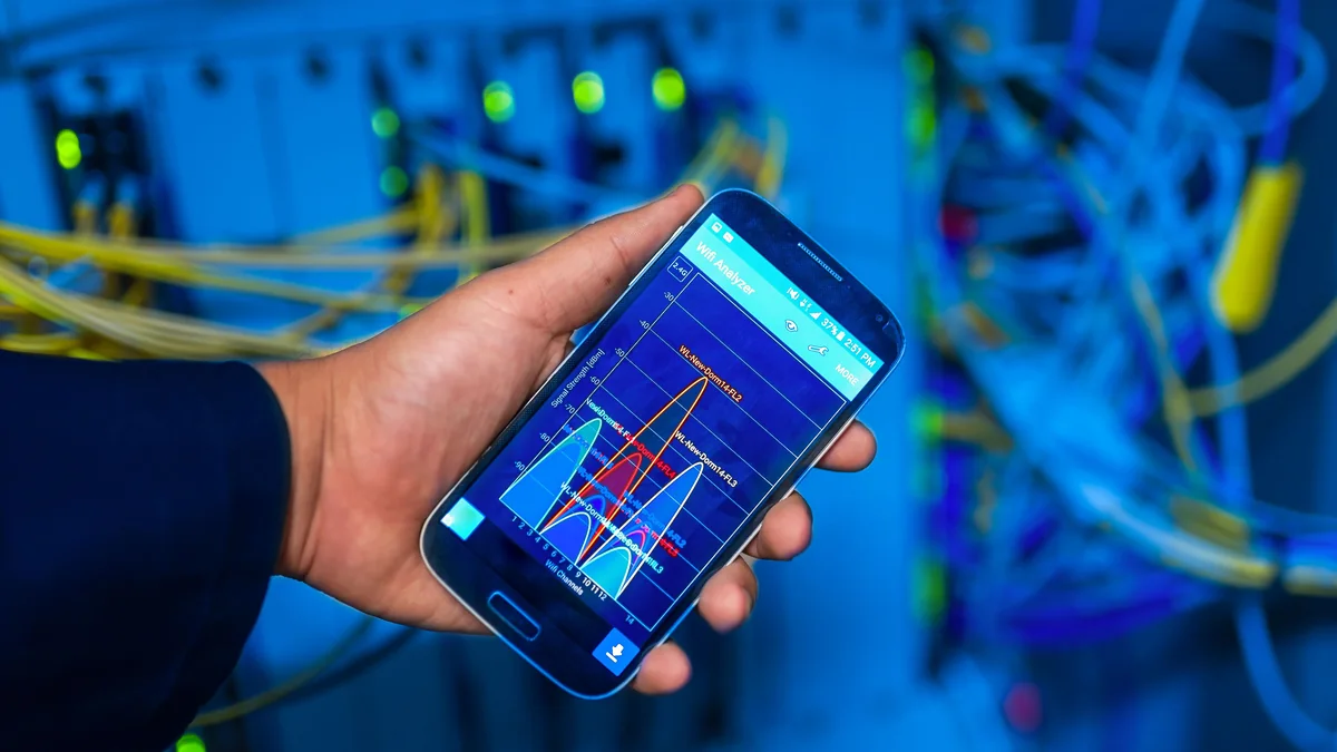 Celular mostra análise de rede sem fio diante de equipamentos conectados.