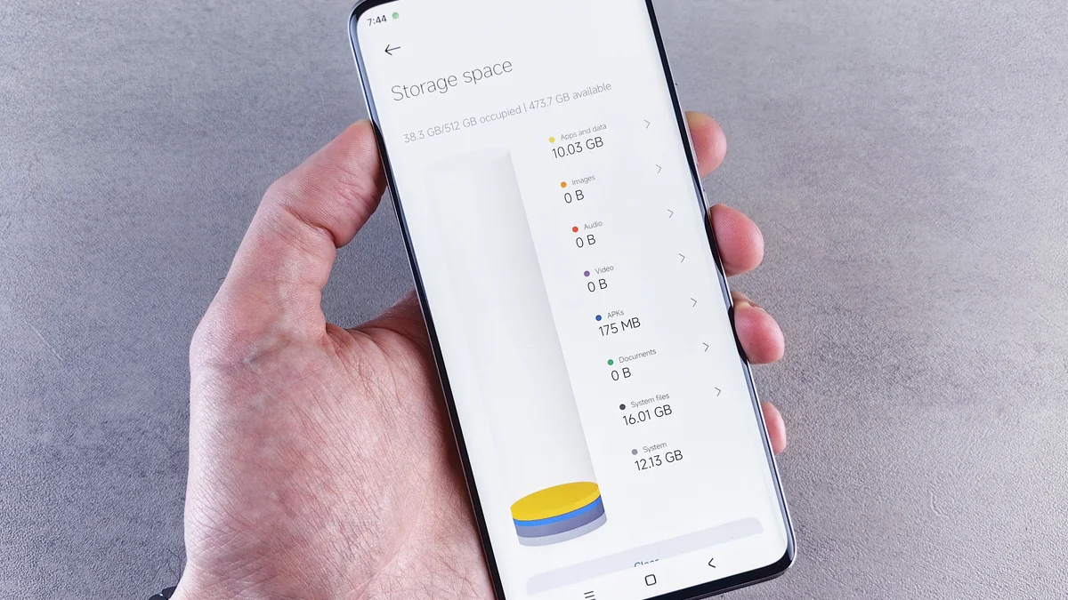 Mão segura celular com painel de uso do armazenamento.