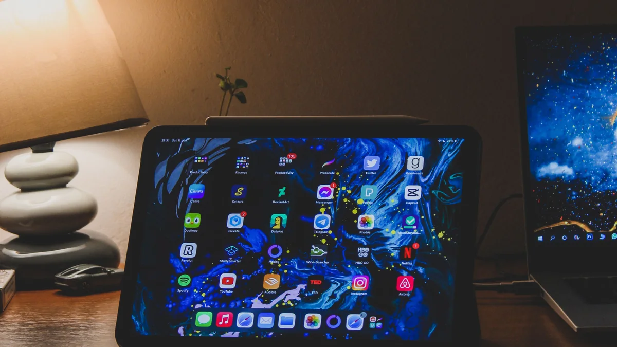 Tablet e notebook juntos em uma mesa de trabalho.