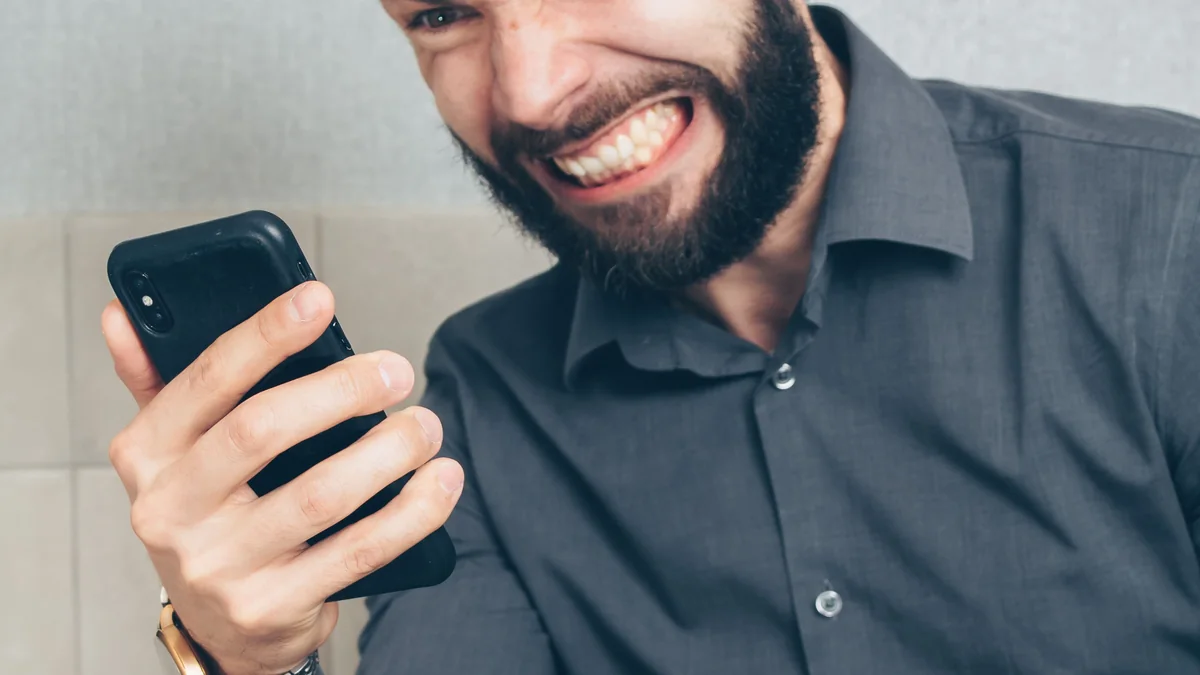 Pessoa frustrada enquanto segura um smartphone.