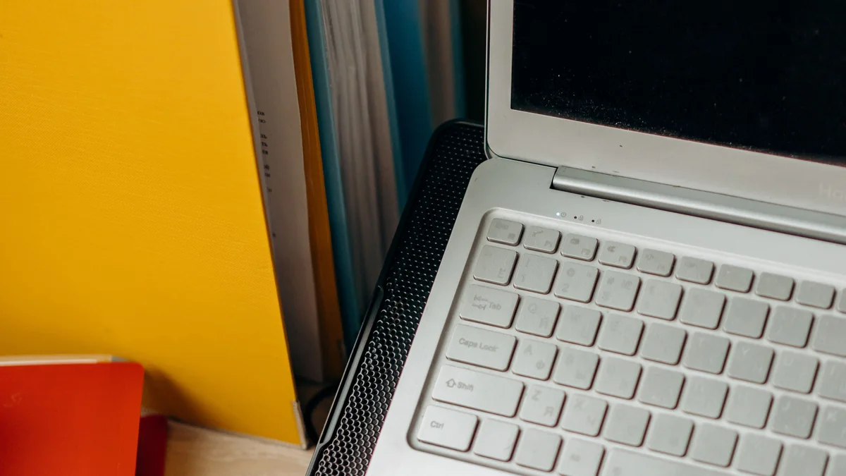 Notebook e pastas de arquivos em uma mesa organizada.